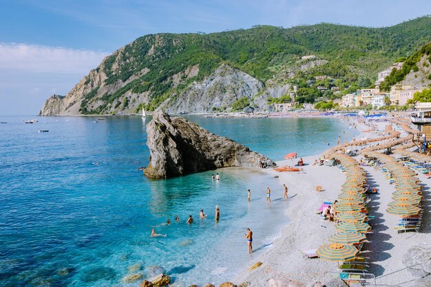 Gente sulla roccia sul mare contro il cielo