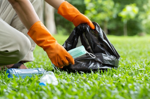 Gentili volontari ecologici che tengono la maschera facciale usata per prevenire i germi e raccogliere immondizia