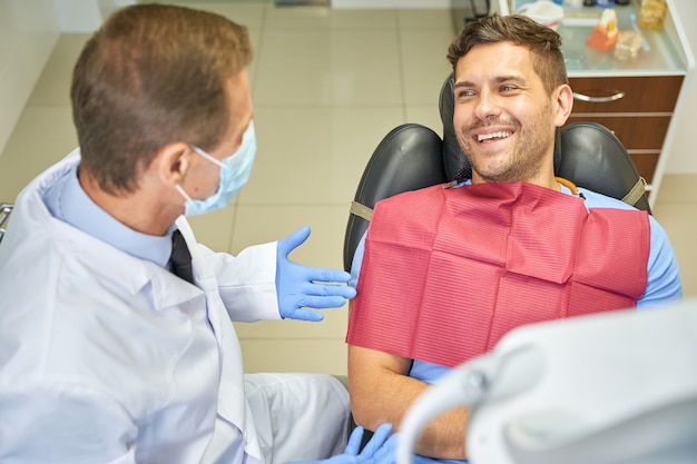 Gentiluomo gioioso che sorride a un appuntamento dal dentista