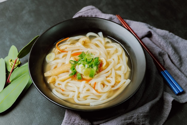 검은색 그릇에 담긴 한국 음식 멸치 칼국수 요리