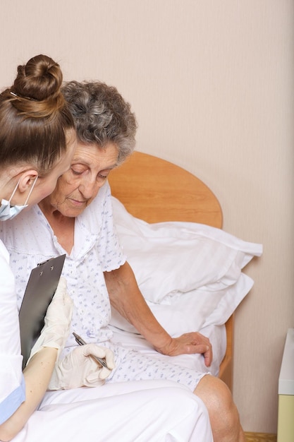 Geriatra visita una donna anziana tra i 70 e gli 80 anni nel suo reparto