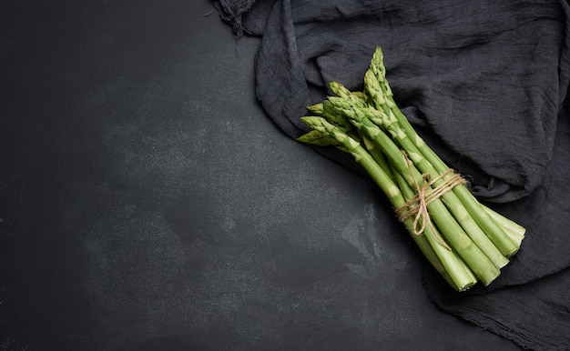 Germogli di asparagi verdi freschi su sfondo nero Vista dall'alto