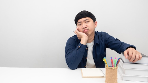 Gesto dell'uomo annoiato dal lavoro e dalla lettura del libro sullo spazio della copia del tavolo