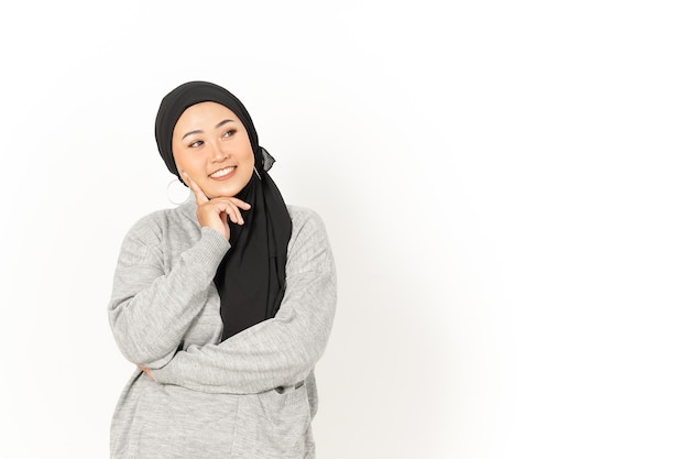 Gesto di pensiero della bella donna asiatica che indossa l'hijab isolato su sfondo bianco