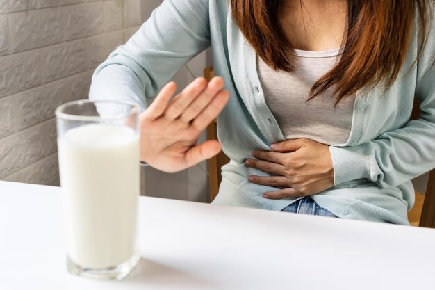 Gesto femminile fermarsi o dire no a bere latte Intolleranza al lattosio concetto di allergia alimentare Primo piano