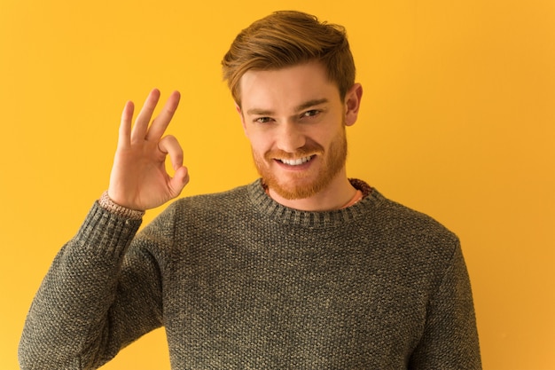 Gesto giusto facente allegro e sicuro del giovane primo piano del fronte dell'uomo di redhead