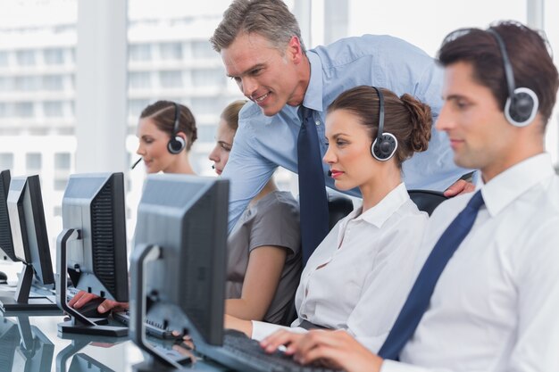 Gestore sorridente che aiuta l&#39;agente del call center