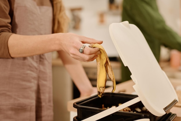 Gettare la buccia nel bidone della spazzatura con il compost