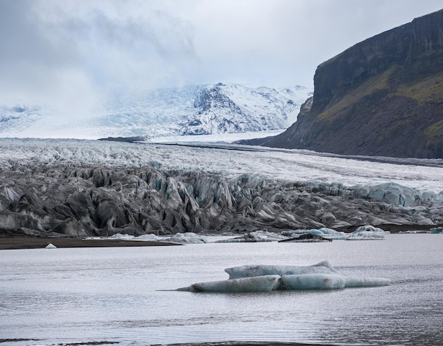 Ghiacciaio Skaftafellsjokull Islanda La lingua del ghiacciaio scorre dalla calotta glaciale Vatnajokull o dal ghiacciaio Vatna vicino al vulcano subglaciale Esjufjoll Laguna glaciale con blocchi di ghiaccio e montagne circostanti