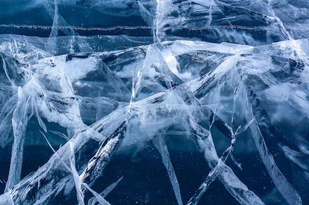 Ghiaccio blu trasparente con molte crepe. Il ghiaccio è spesso. Orizzontale.