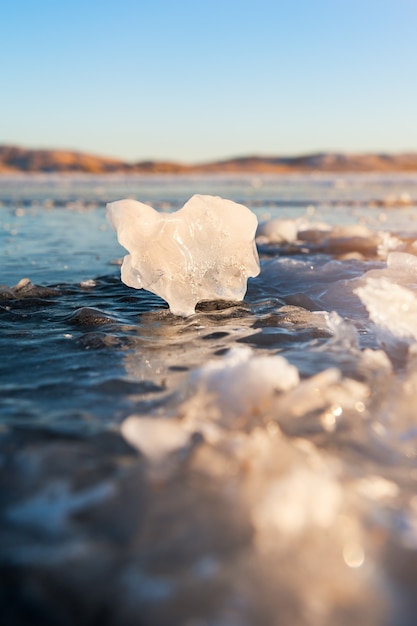 Ghiaccio sul lago ghiacciato al tramonto. Immagine macro, profondità di campo ridotta. Bella natura invernale