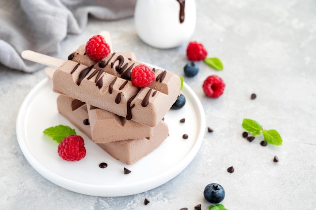 Ghiaccioli di gelato al cioccolato fatti in casa con spazio per la copia di lamponi e mirtilli freschi