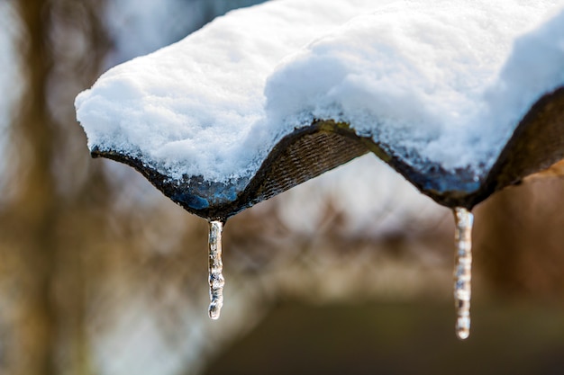 Ghiaccioli di inverno che pendono dal primo piano del tetto