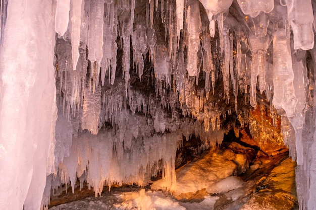 Ghiaccioli in grotta sul lago Baikal al tramonto