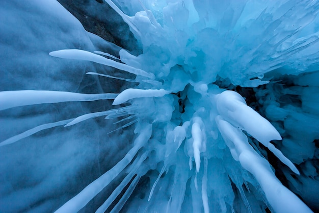 Ghiaccioli lunghi e sciolti sparati dal basso. Ghiaccioli taglienti di colore blu. Un sacco di ghiaccio intorno. Sfondo invernale congelato.