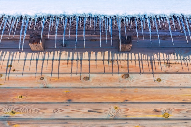 Ghiaccioli sul primo piano del tetto dell'annata in inverno