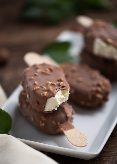 Ghiacciolo al cioccolato con mandorle sul tavolo vintage in legno. Avvicinamento