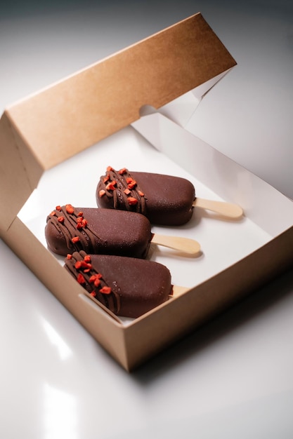 Ghiacciolo al cioccolato decorato con frutta in una scatola di cartone