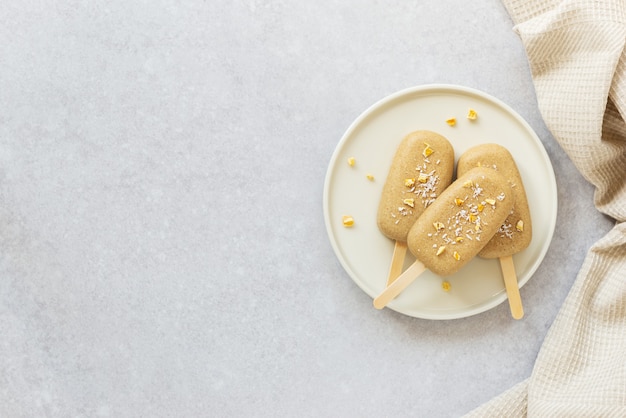 Ghiacciolo fatto in casa con anacardi al cioccolato e pezzi di mango su un piatto