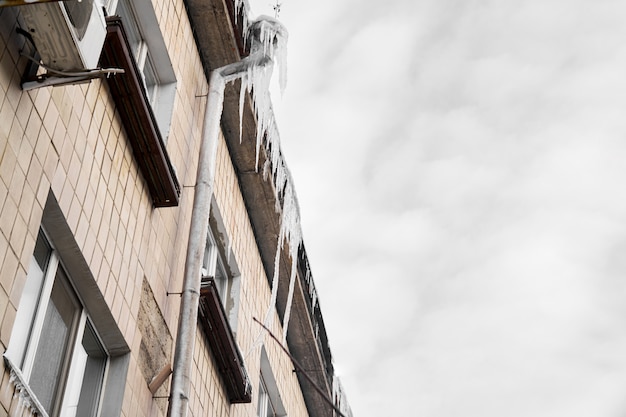 Ghiacciolo sul tetto del tubo, edificio coperto di ghiaccioli