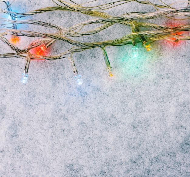 Ghirlanda di luci multicolori sulla neve bianca