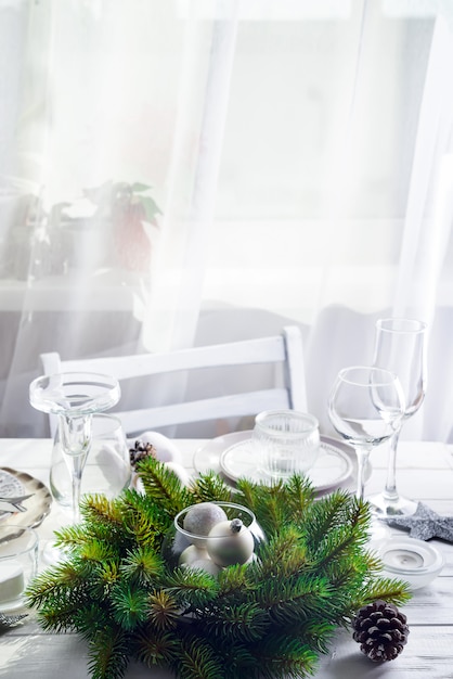 Ghirlanda di Natale con i giocattoli sul tavolo con Silver Christmas Table Setting