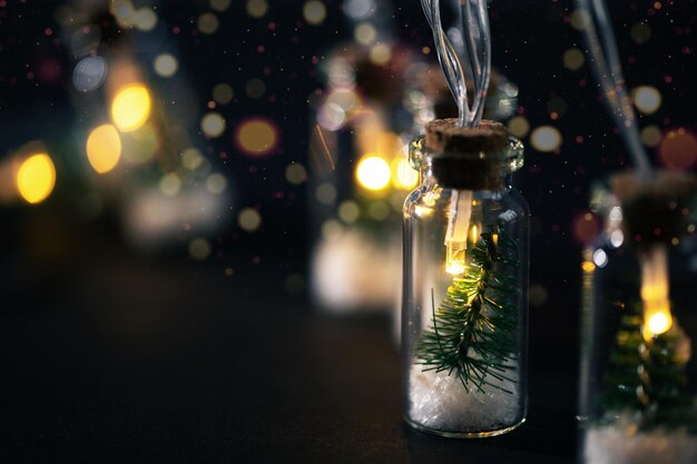 Ghirlanda di Natale creativa con luci bokeh Albero di Natale in un barattolo di vetro con neve Biglietto di auguri di Natale