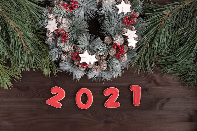 Ghirlanda di Natale e la scritta nel 2021 di pan di zenzero su fondo in legno. Anno nuovo concetto.