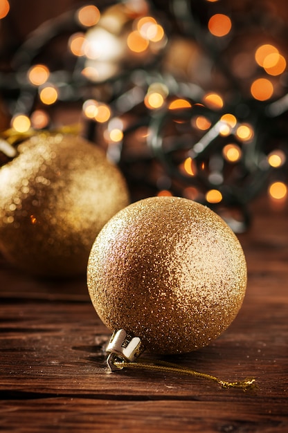 Ghirlanda di Natale e palline d'oro sul tavolo di legno