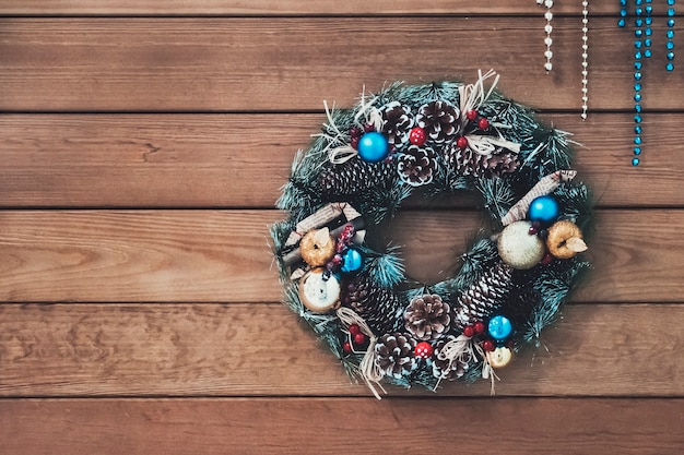 Ghirlanda natalizia di coni, rami di abete e bacche, decorazioni di Capodanno. bella ghirlanda di abete con coni, palline e frutta.