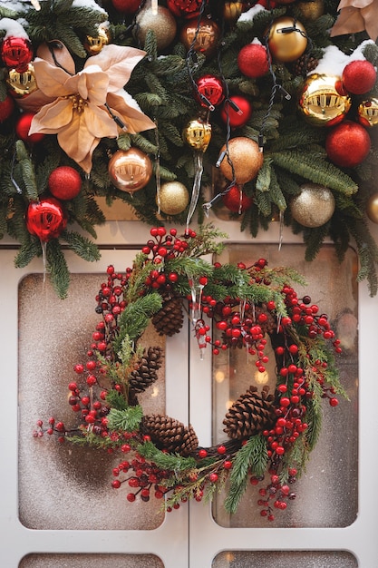 Ghirlanda natalizia di rami di abete e decorazioni appese sullo sfondo di una finestra ghiacciata