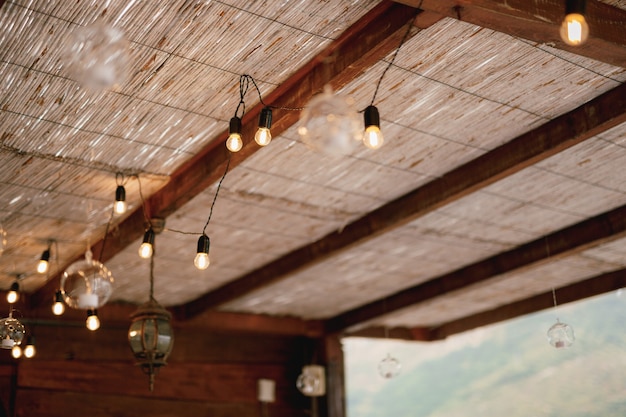 Ghirlanda su un filo di lampadine a led sotto un tetto di paglia