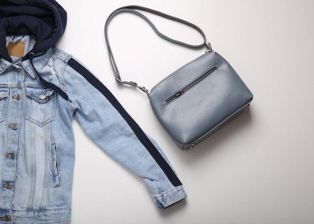 Giacca in denim con cappuccio e borsa su sfondo bianco Vista dall'alto