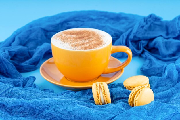 Giallo tazza di caffè e amaretti su sfondo blu