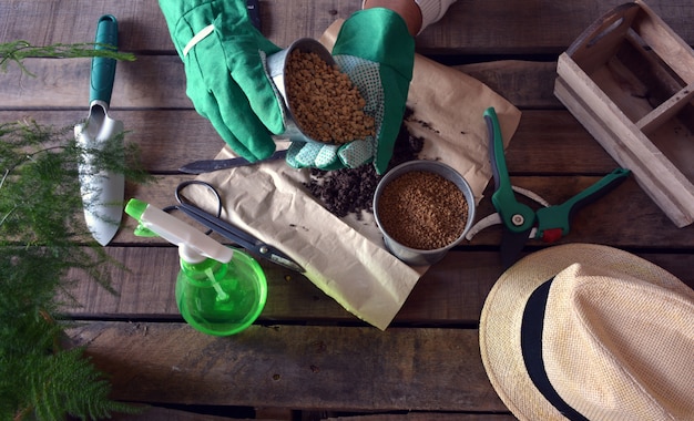 Giardiniere che fa il lavoro di giardinaggio ad una tavola rustica