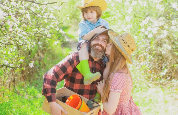 Giardiniere di famiglia in passeggiata nel giardino o nel parco. Genitorialità insieme concetto di svago.