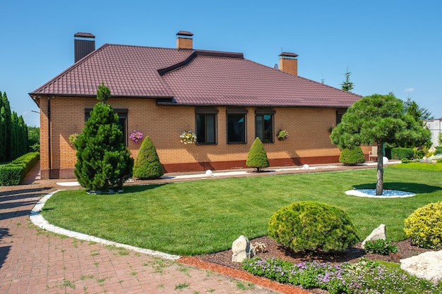 Giardino del cortile posteriore con cespugli e arbusti di bonsai ben tagliati di fronte alla villa