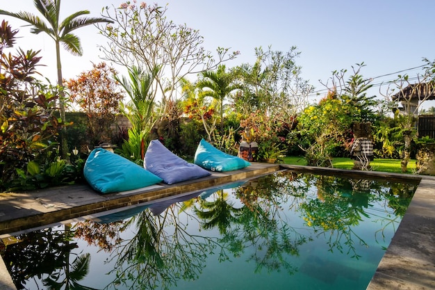 Giardino tropicale in stile Bali con piscina e concetto di vacanza a sacco e vacanze estive