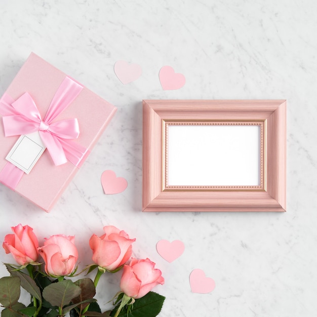 Giftbox e fiore di rosa rosa sulla superficie del tavolo bianco in marmo per il concetto di design di saluto di festa della mamma.