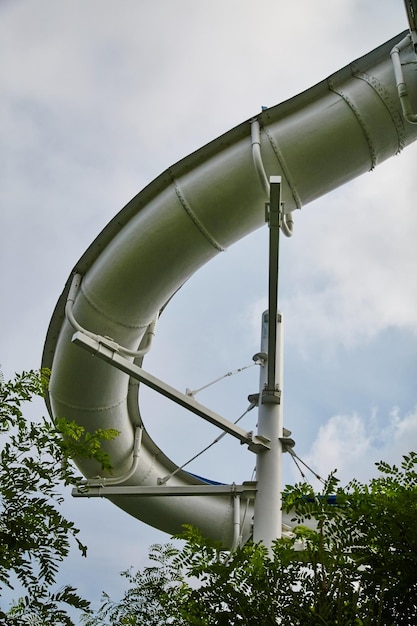 Gigante scivolo d'acqua curvo con fogliame verde vista dal suolo