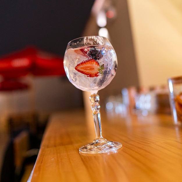 gin tonic in bicchiere di vetro con frutti rossi, fragola e lampone