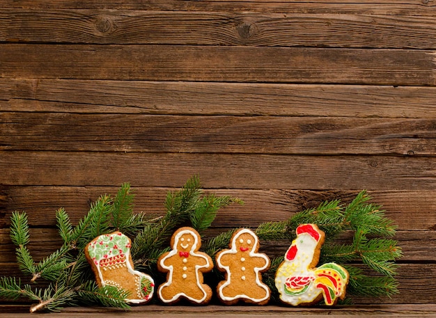 Gingerbread calzino gallo uomini di pan di zenzero Ramo di Furtree sullo sfondo di una parete di legno con spazio per il testo