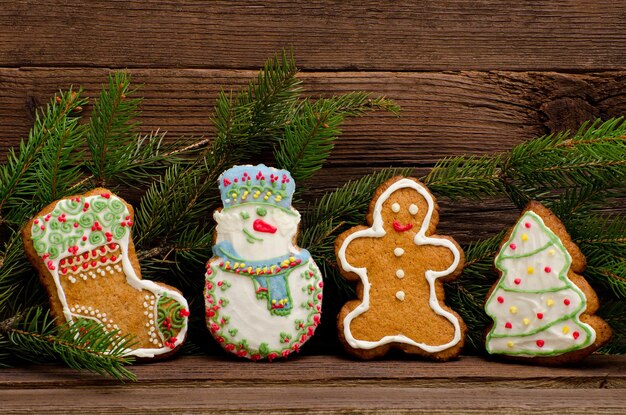 Gingerbread calzino pupazzo di neve uomo abete ramo di abete rosso su uno sfondo di una parete di legno da vicino