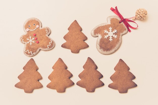 Gingerbread cookies a forma di alberi di Natale, uomo e guanti su uno sfondo bianco. Vista dall'alto