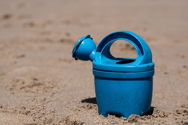 Giocando sulla spiaggia con l'annaffiatoio