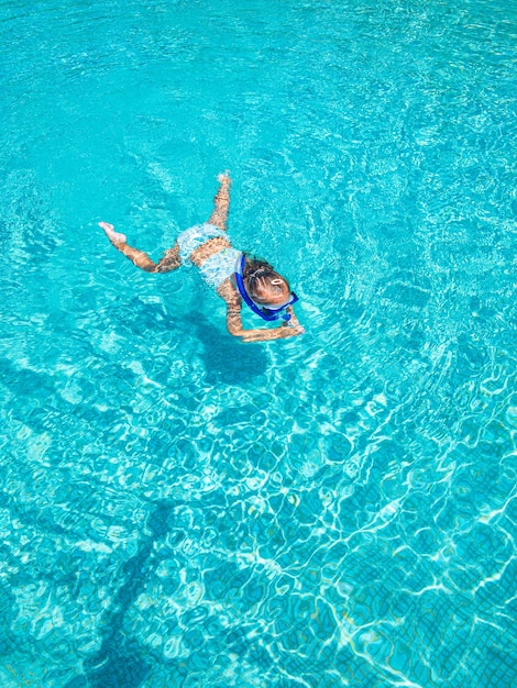Giocare in acqua Vista dall'alto della bambina che nuota in piscina Concetto di vacanza estiva