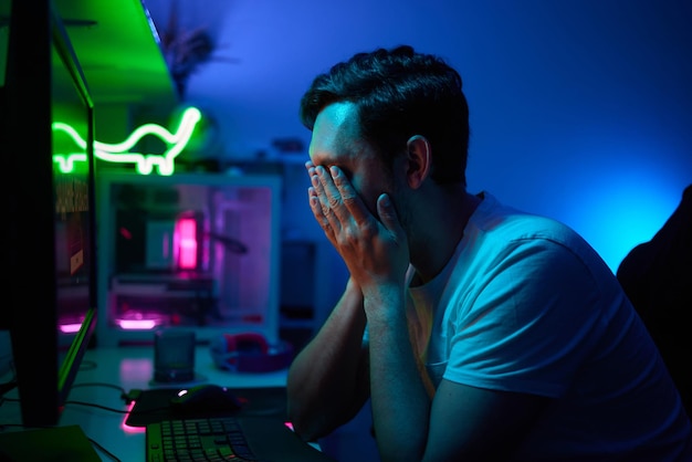 Giocatore che guarda lo schermo del suo computer contemplando la sua prossima mossa in un videogioco online