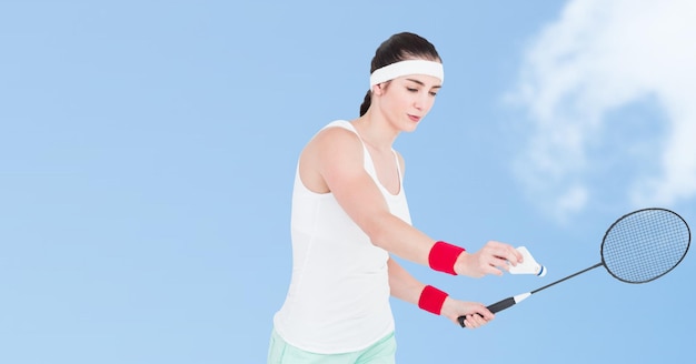 Giocatore di badminton femminile asiatico che gioca contro le nuvole nel cielo blu