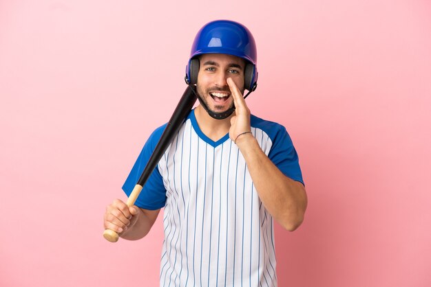 Giocatore di baseball con casco e pipistrello isolato su sfondo rosa che grida con la bocca spalancata