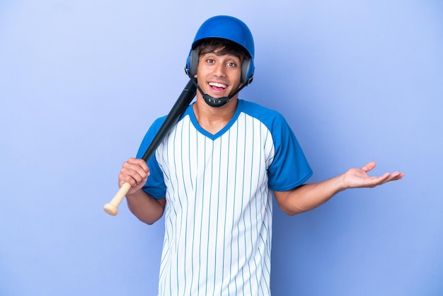 Giocatore di baseball uomo caucasico con casco e mazza isolato su sfondo blu con espressione facciale scioccata